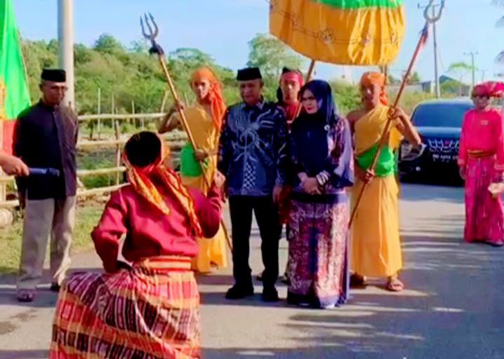 Bupati Kepulauan Selayar, Muh. Natsir Ali (baju biru) disambut dengan atraksi a'ngaru saat menghadiri acara pertunjukan seni Kelong Sino ri Bungaiya, Kamis (27/11/2025). (Foto: Istimewa)