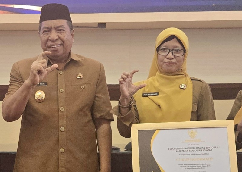 Kepala Desa Bontosunggu Patmahwati, didampingi Wakil Bupati Kepulauan Selayar, Muhtar saat menerima penghargaan pada Anugerah Keterbukaan Informasi Publik dari Komisi Informasi Sulsel (Foto:  kepulauanselayarkab.go.id)
